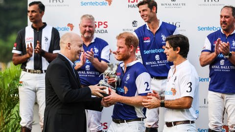 Prinz Harry bekommt bei einem Polo-Turnier in Singapur ein Trophäe überreicht.