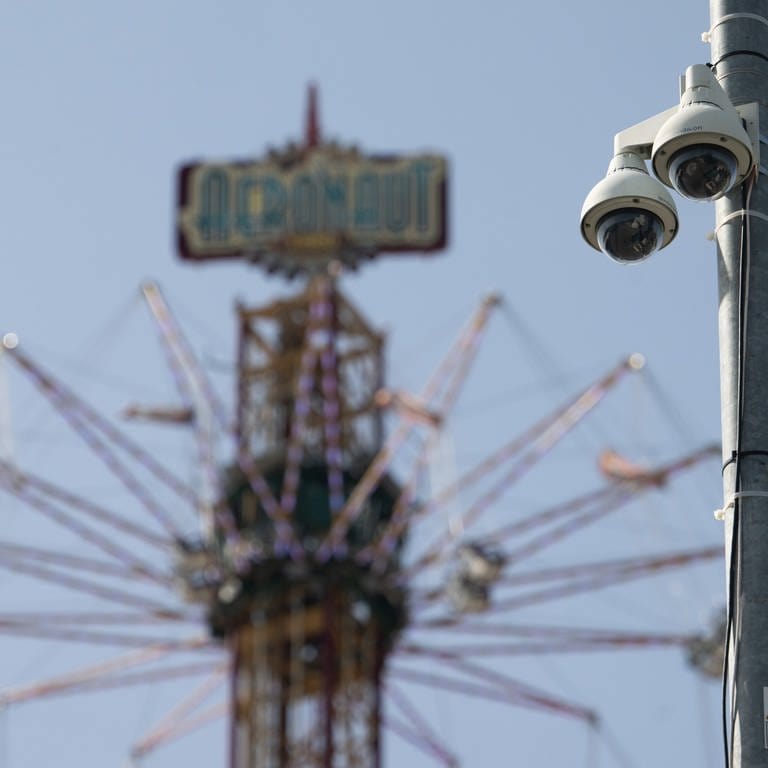 Kameras sind an einem Mast auf dem Festgelände des Stuttgarter Frühlingsfestes zu sehen. 
