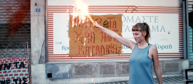 „#widerstand“: Helene zündet am Ende der Demo in Athen, gegen die geplante Räumung der besetzten Häuser, ein Bengalo an. © SWREikon Media
